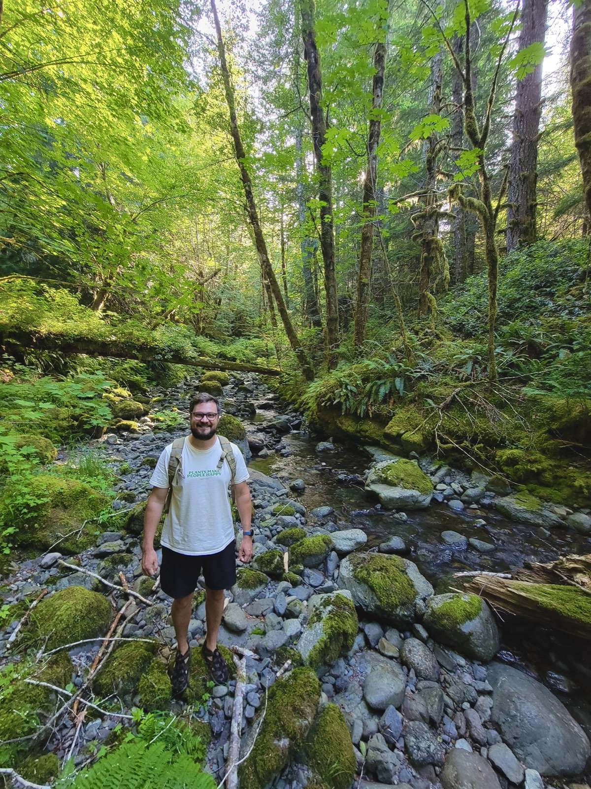 Francis in a lush BC forest beside a creek